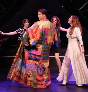 Joseph (David S. Humphrey, center) trots out his stuff as the Narrator (Joy Yandell, right) looks on. (Photos by Ken Jacques)